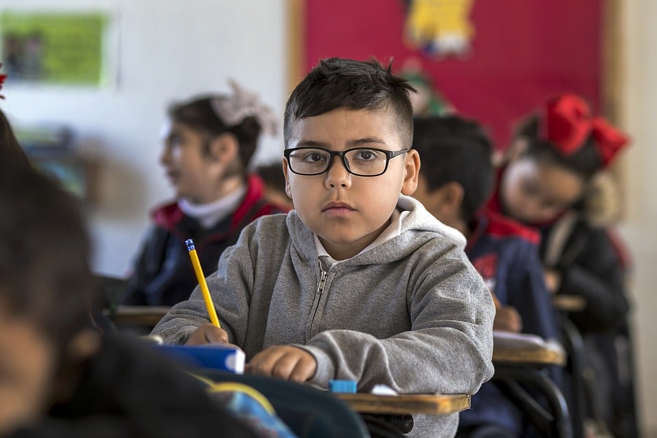boy looking at camera with pencil in hand